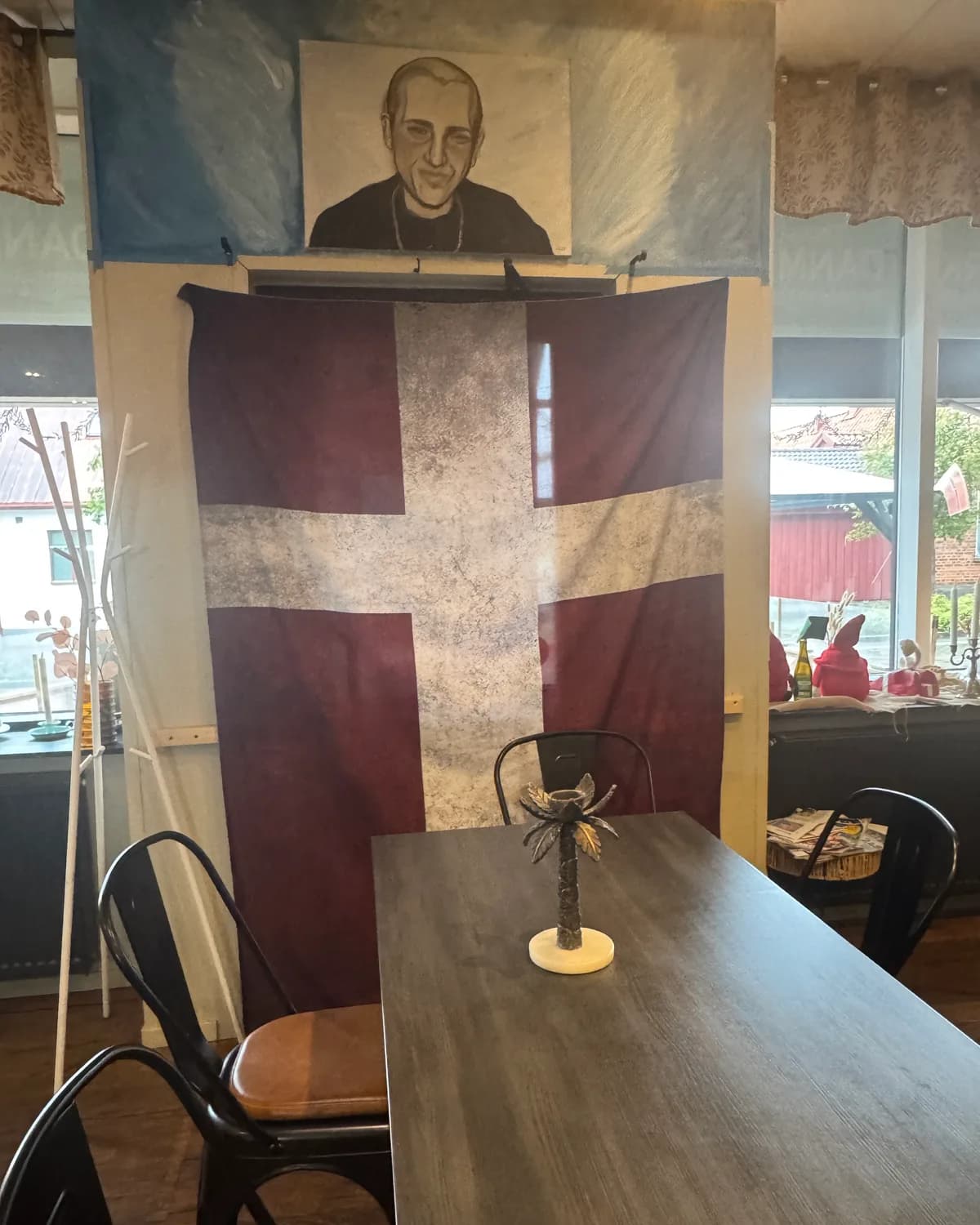 Bord vid fönstret inne i restaurangen, med en stor Dannebrog på väggen bakom
