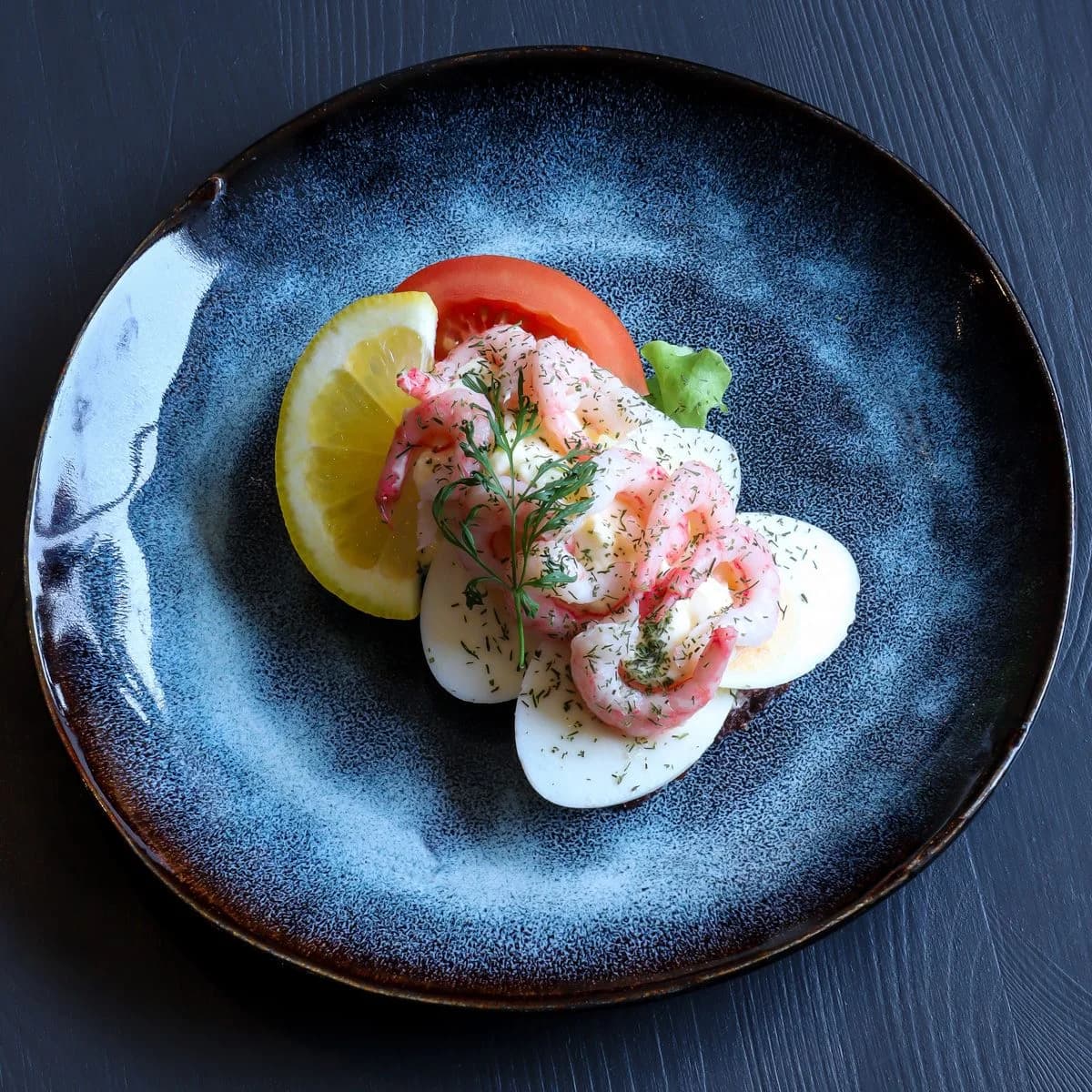 Smørrebrød med ägg, handskalade räkor, dill, tomat och citron