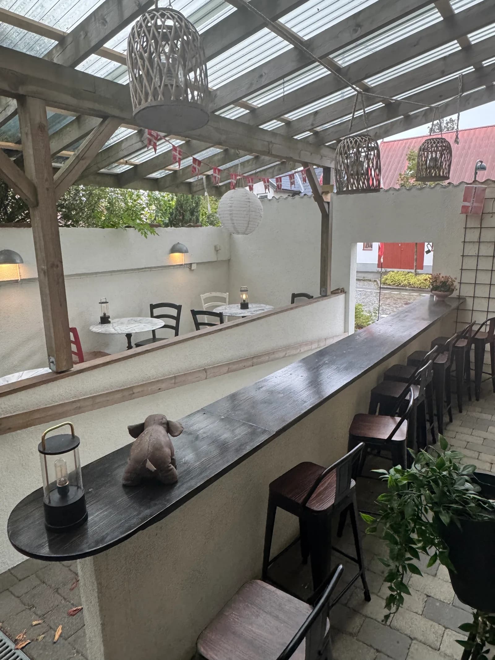 Uteserveringen på gården bakom restaurangen, under tak med bardisk och stolar