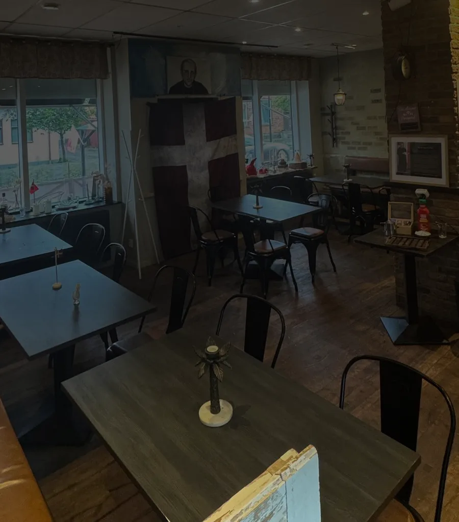Restaurangens matsal med dukade bord och en stor Dannebrog på väggen